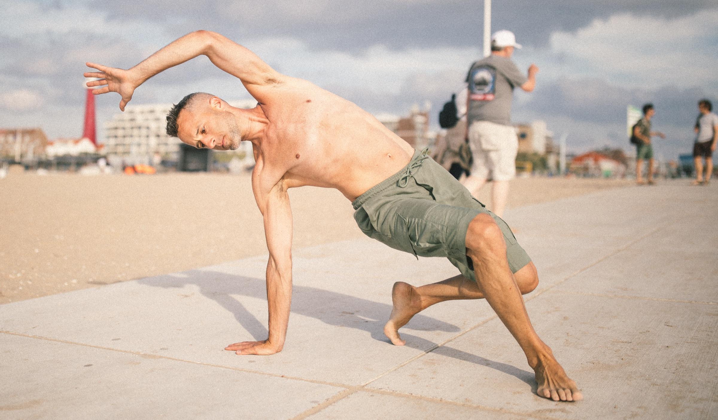 Vita in a strong side-plank pose on the beach